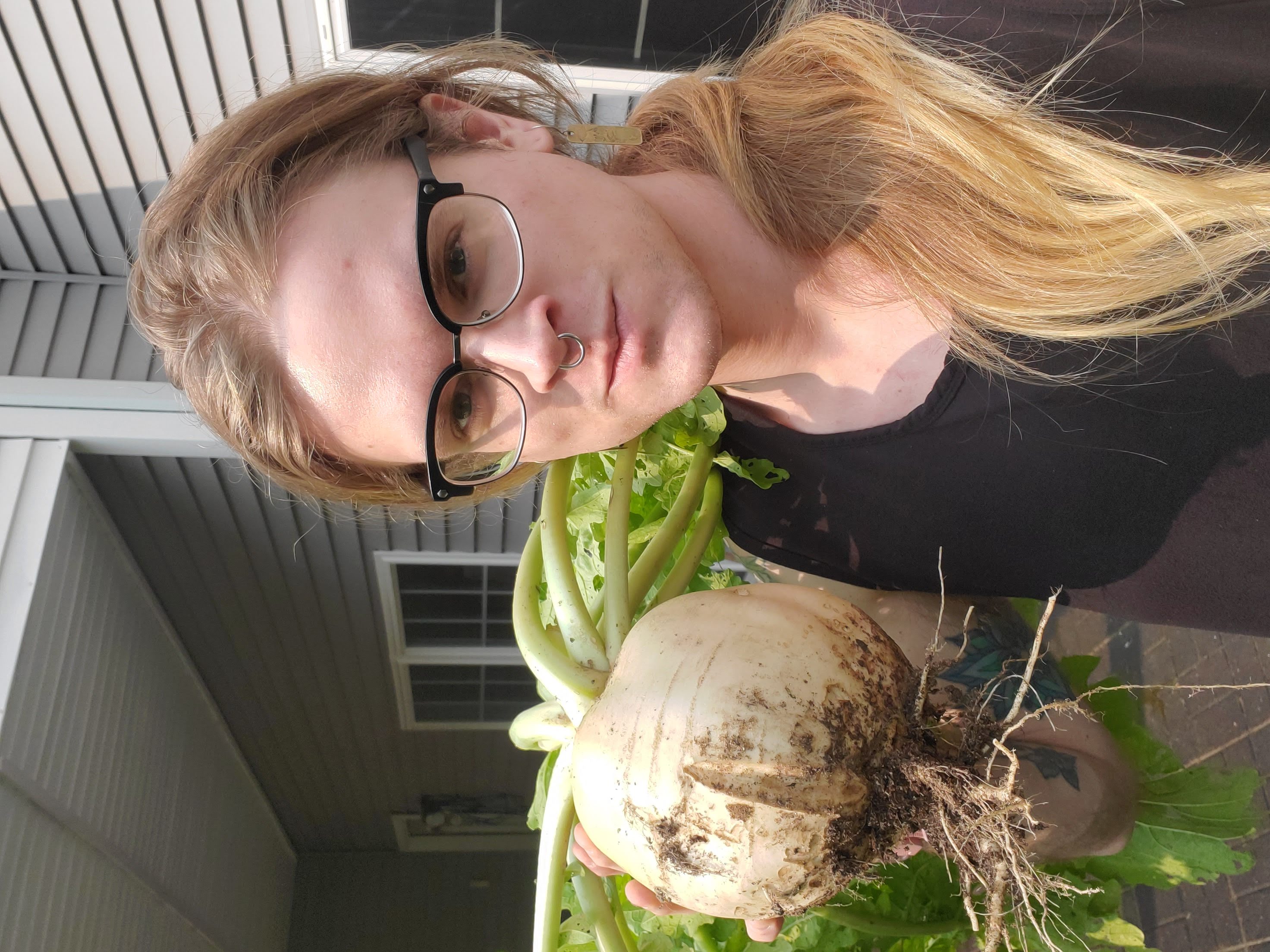 A photo of Morgan holding a turnip close to the size of her head.